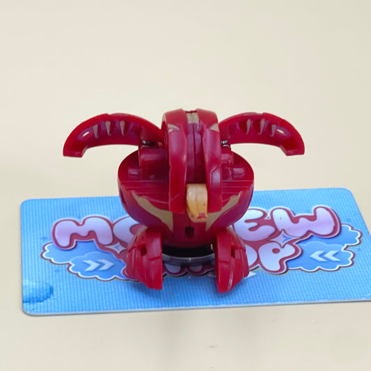 A red toy with a yellow head is sitting on a blue surface with a pink and blue design.
