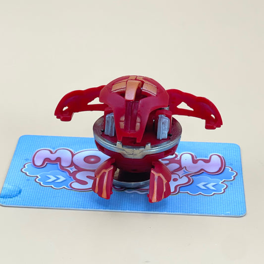 A red toy with a metallic appearance is sitting on a blue surface with a patterned design.