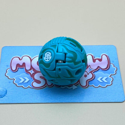 A blue and green toy ball is sitting on a blue and white checkered surface.