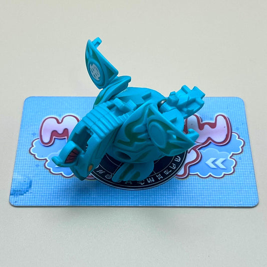 A blue toy figure is sitting on a blue and white checkered surface.