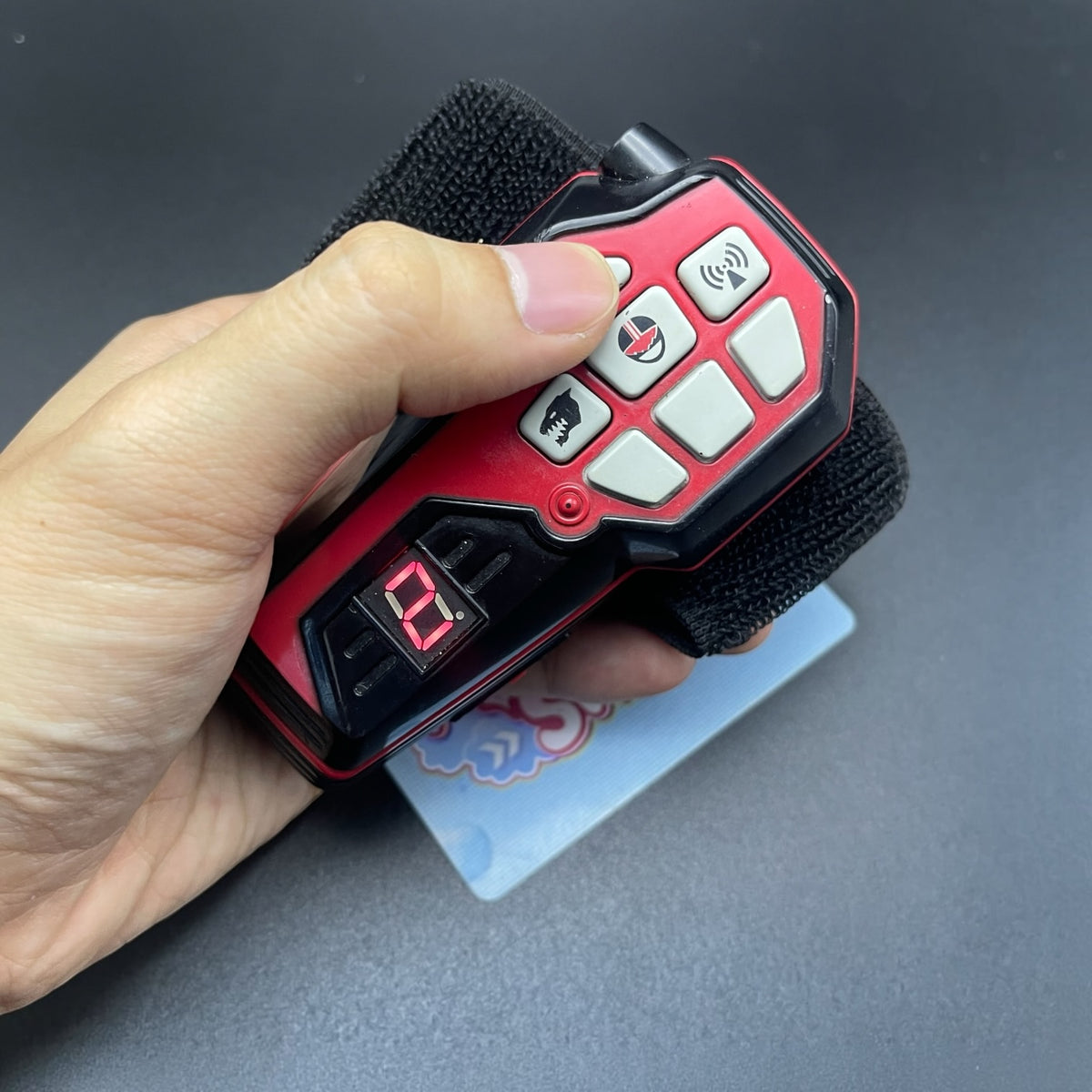 Hand pressing control keypad on Power Rangers Time Force Quantum Morpher with illuminated red digital display   