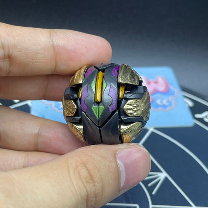 Darkus Seis Tavanel Metal Cross Baku Tech Bakugan in closed sphere ball form held in hand showing attribute symbol.