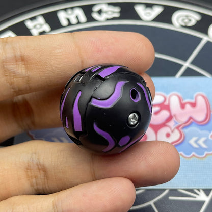 Closed sphere mode of Darkus B1 Centipoid Bakugan showing purple stripe patterns on black surface.