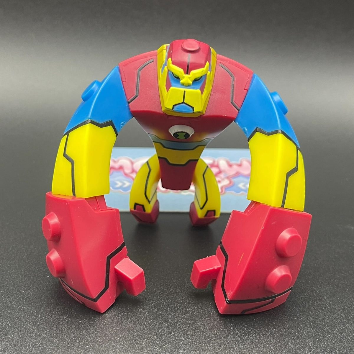 Front view of Bloxx action figure from Ben 10 Omniverse featuring block-like alien body design in red, blue, and yellow.