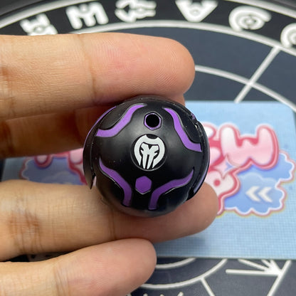 Darkus B1 Centipoid Bakugan in closed sphere ball form held in hand displaying attribute symbol.