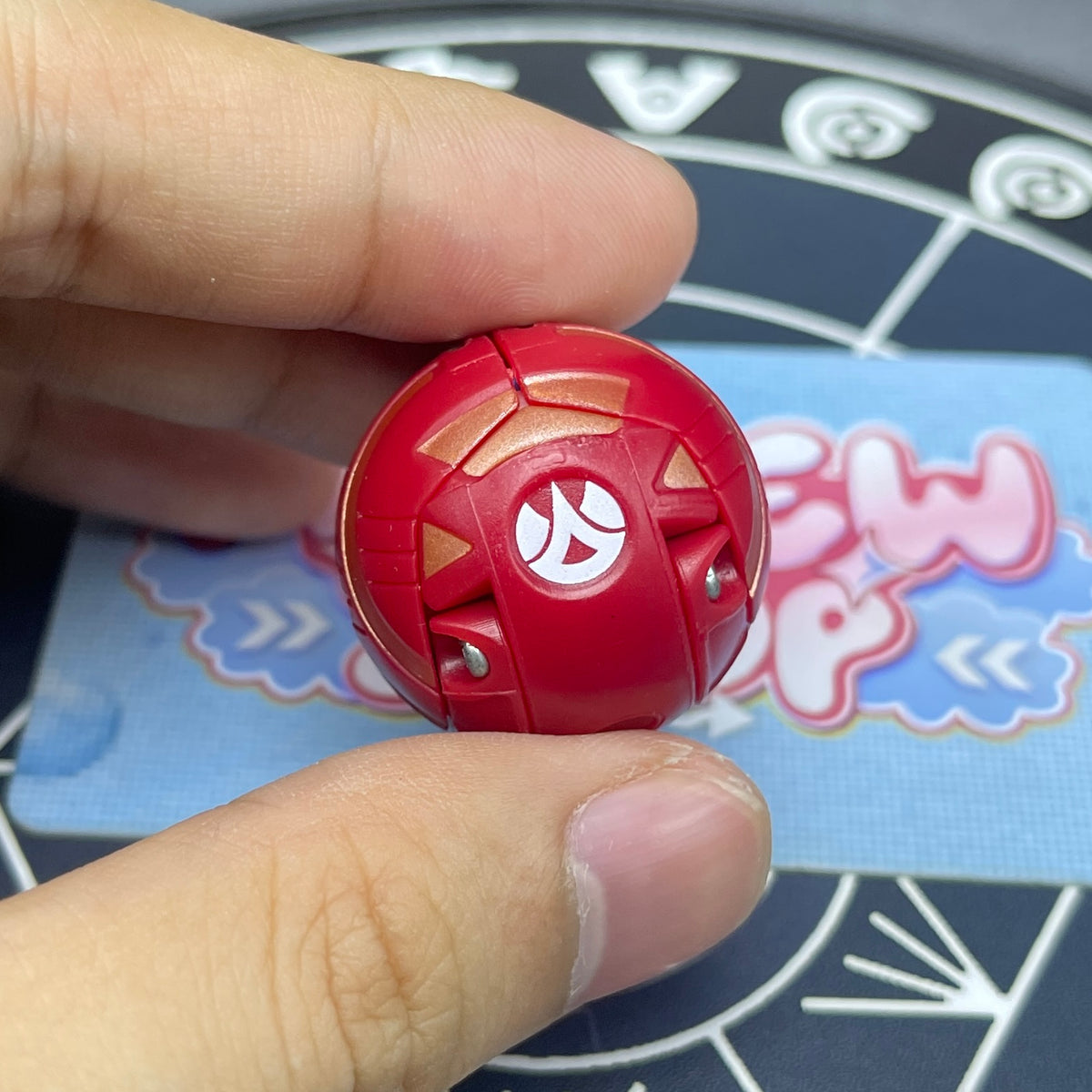Pyrus B1 Griffon Bakugan in closed sphere ball form held in hand displaying attribute symbol.