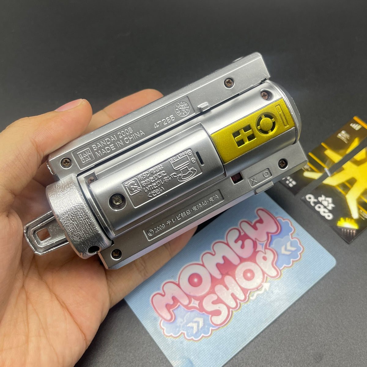 Hand holding closed folding mode of Samurai Gold Morpher prop.